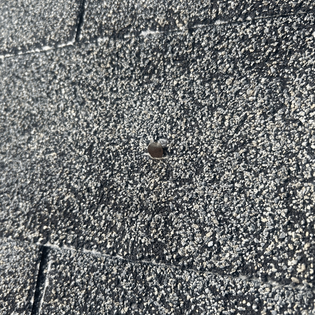 A lifted architectural shingle caused by a popped nail on a Dacula, GA home. Good Shepherd Roofing provides professional roof repair to prevent water damage from loose shingles.